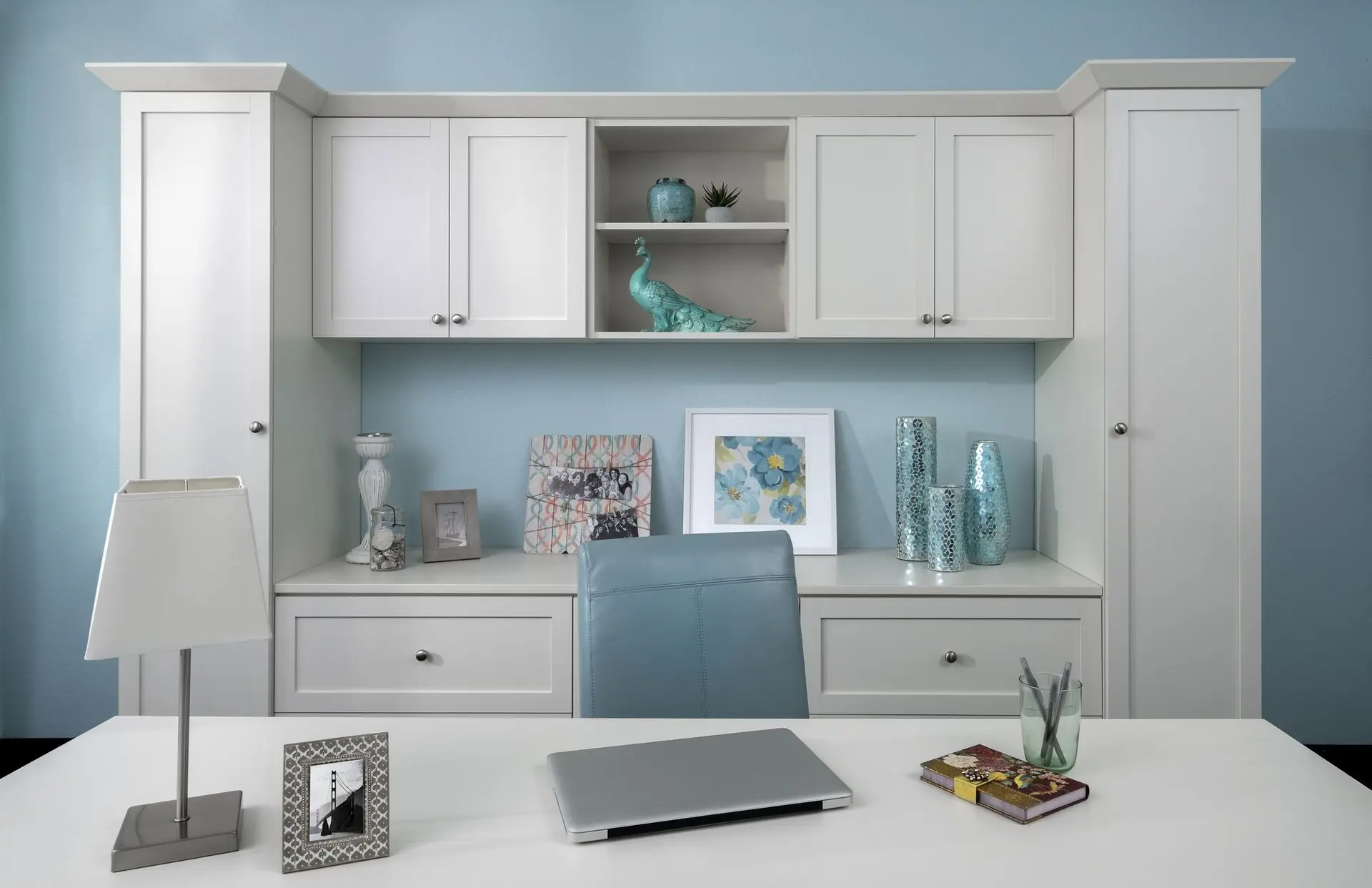 Antique white home office desk setup with a blue rolling chair and laptop on the workspace
