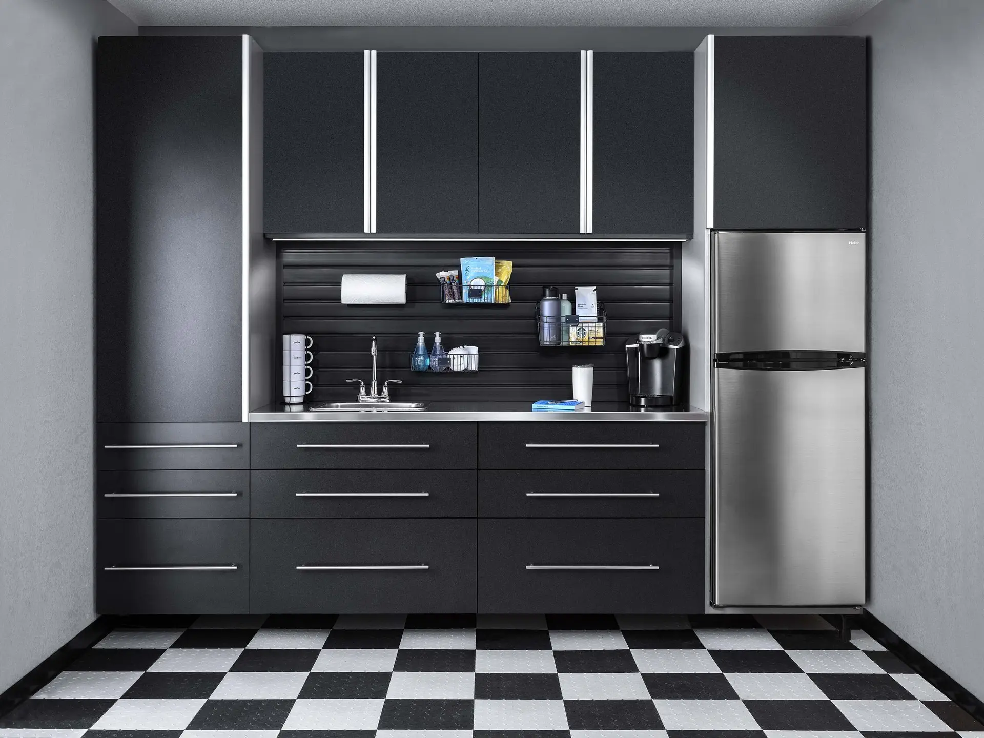 Custom basalt garage cabinets with a dark modern finish next to a stainless steel refrigerator