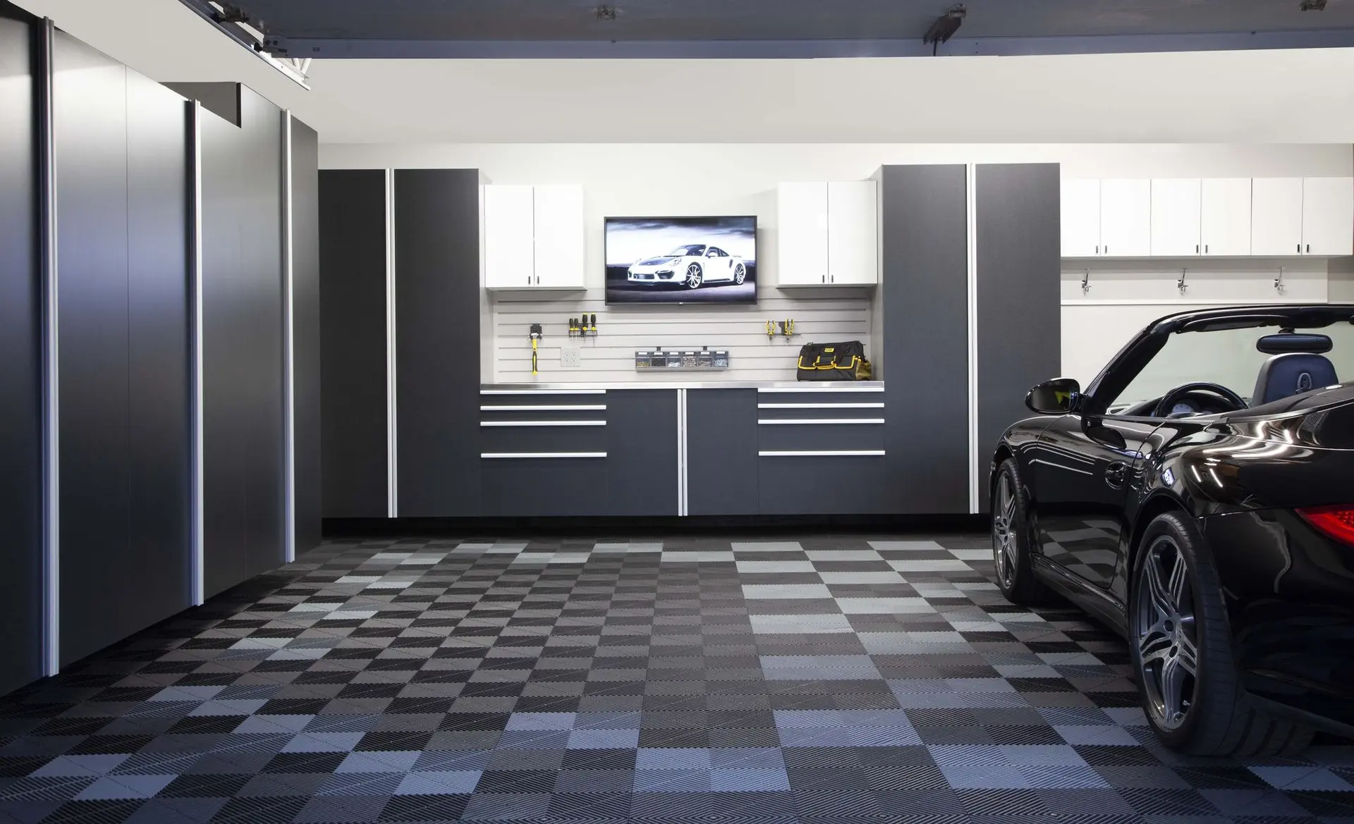 Sleek basalt garage cabinetry with modern long handles and a built in workbench area