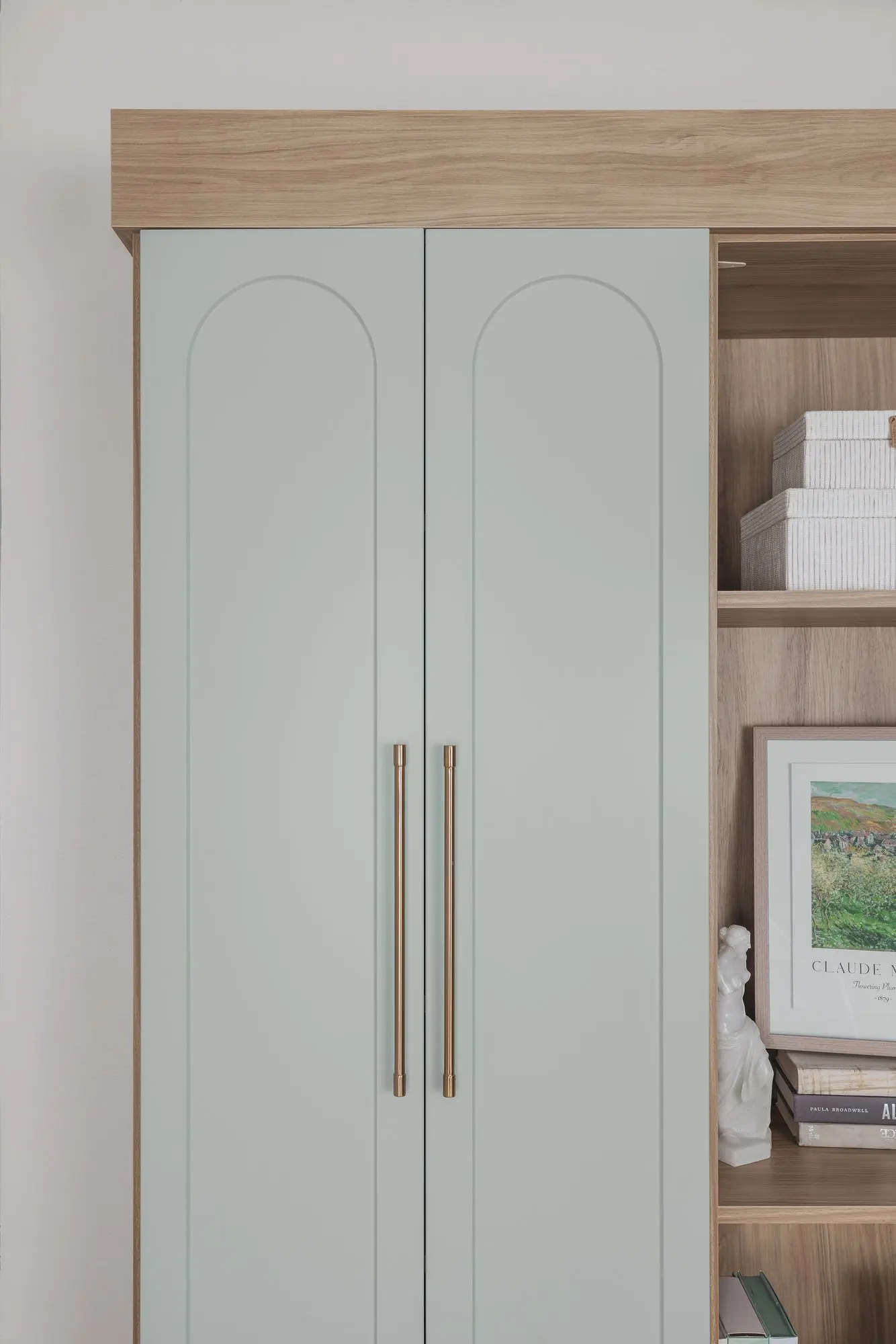 Luxury custom bookshelves near me showcasing matte nickel hardware and soft green shaker doors