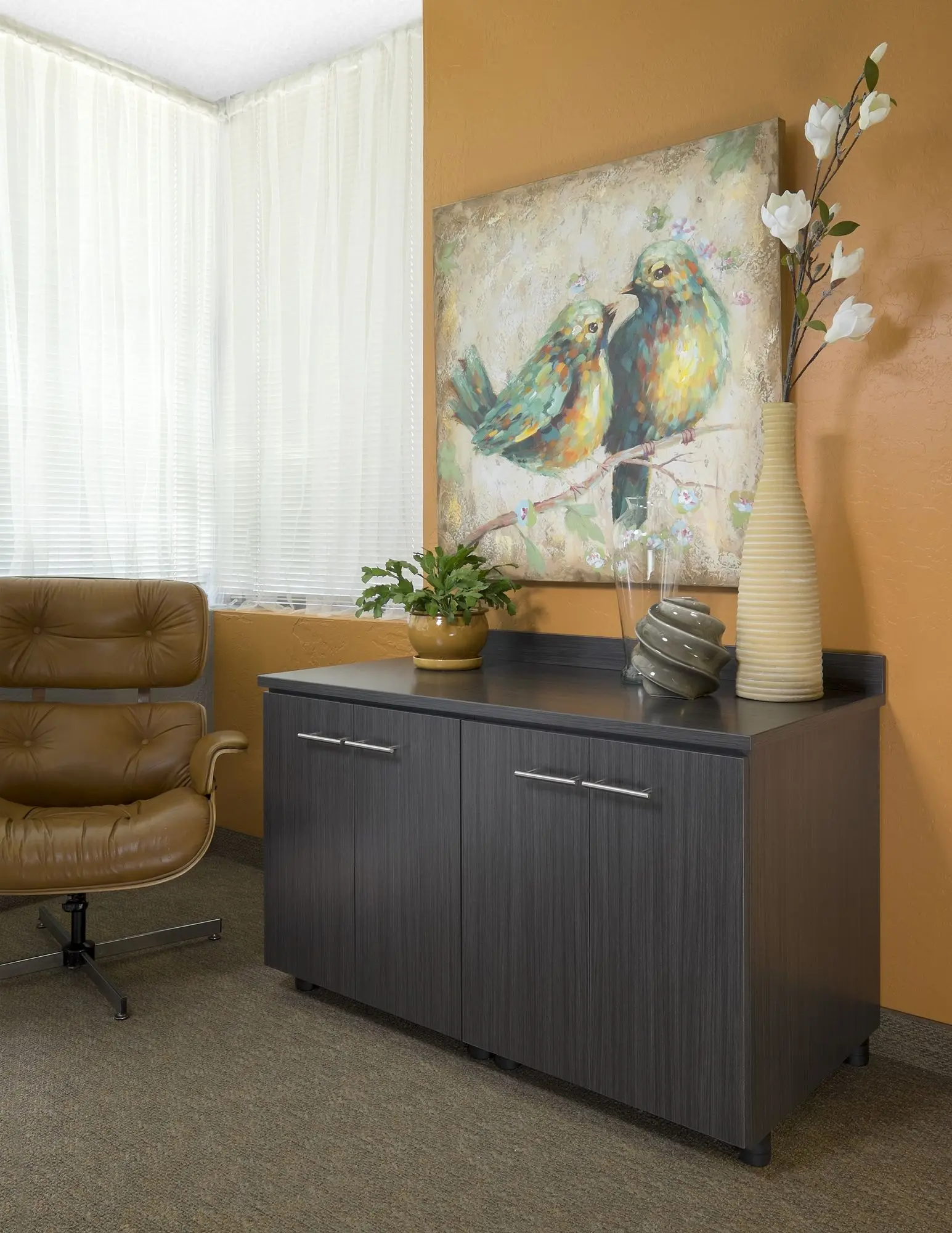 Home office decor for men featuring a dark cabinetry credenza next to a leather lounge chair