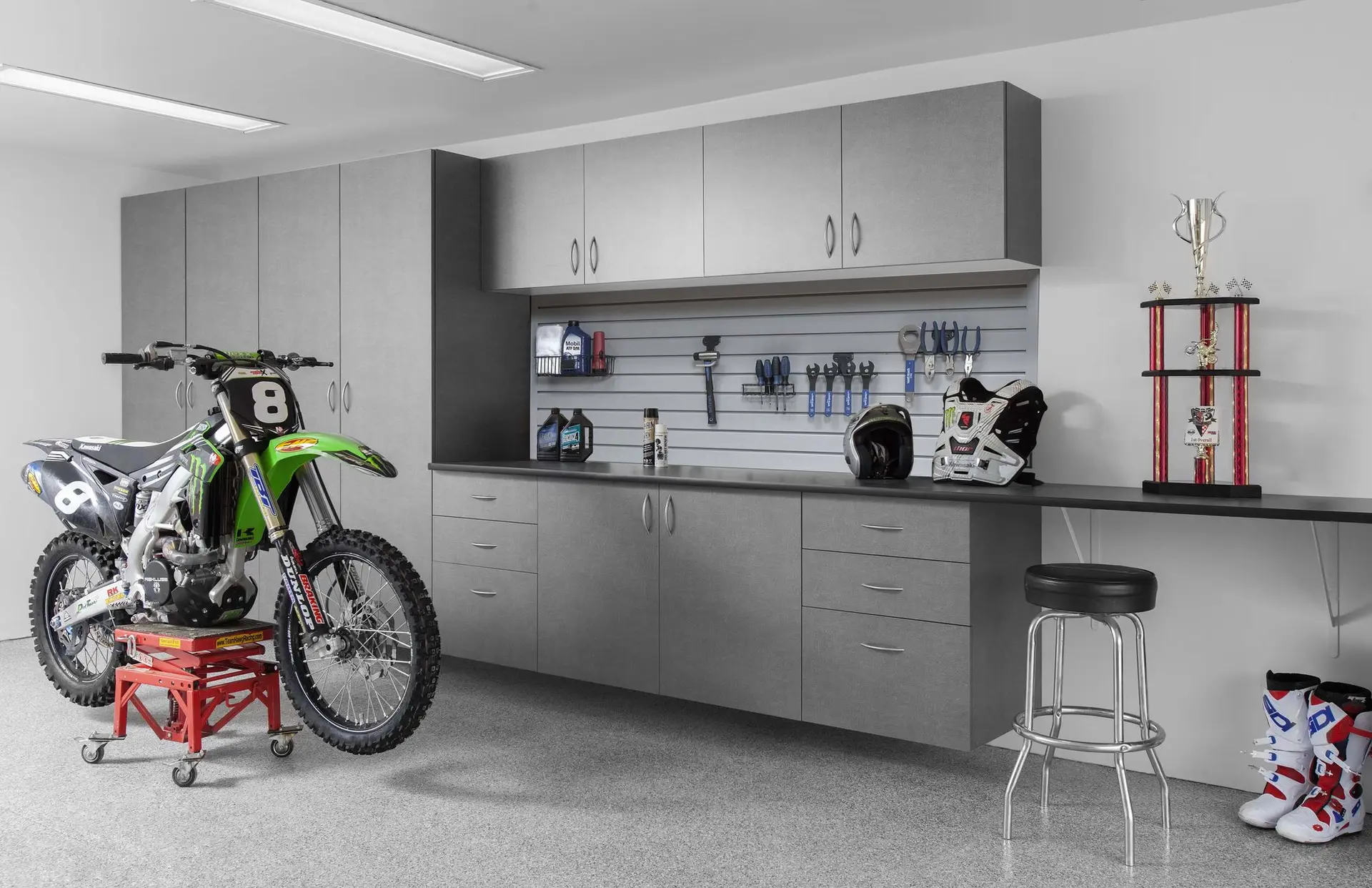Custom pewter garage cabinets and storage system with a dirt bike on a paddock stand