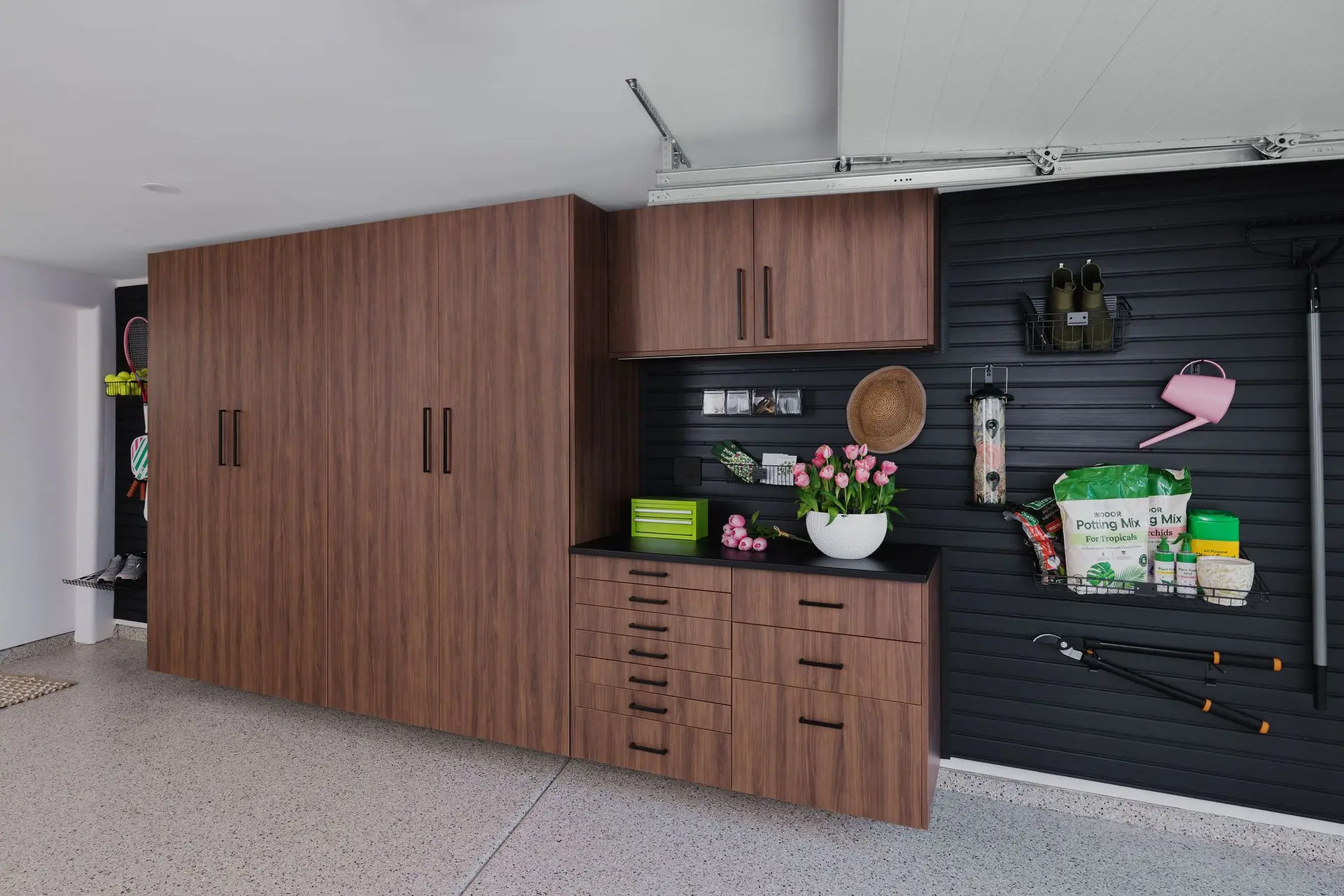 Sleek wood finish garage closets configured for clean hidden residential organization