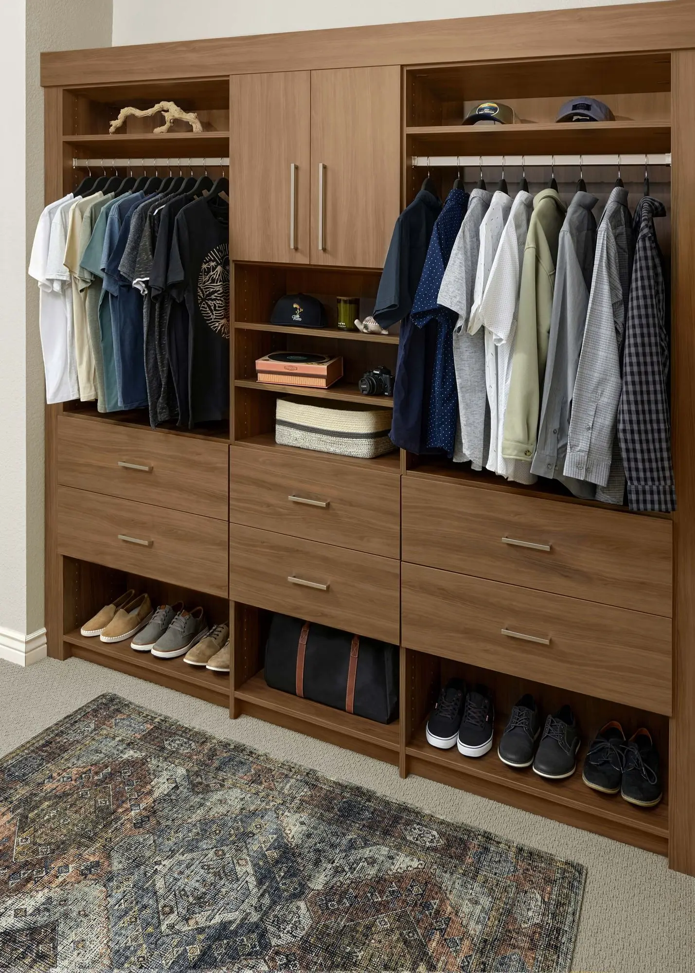 Modern wood grain custom closet systems featuring dedicated dress hanging and drawer space