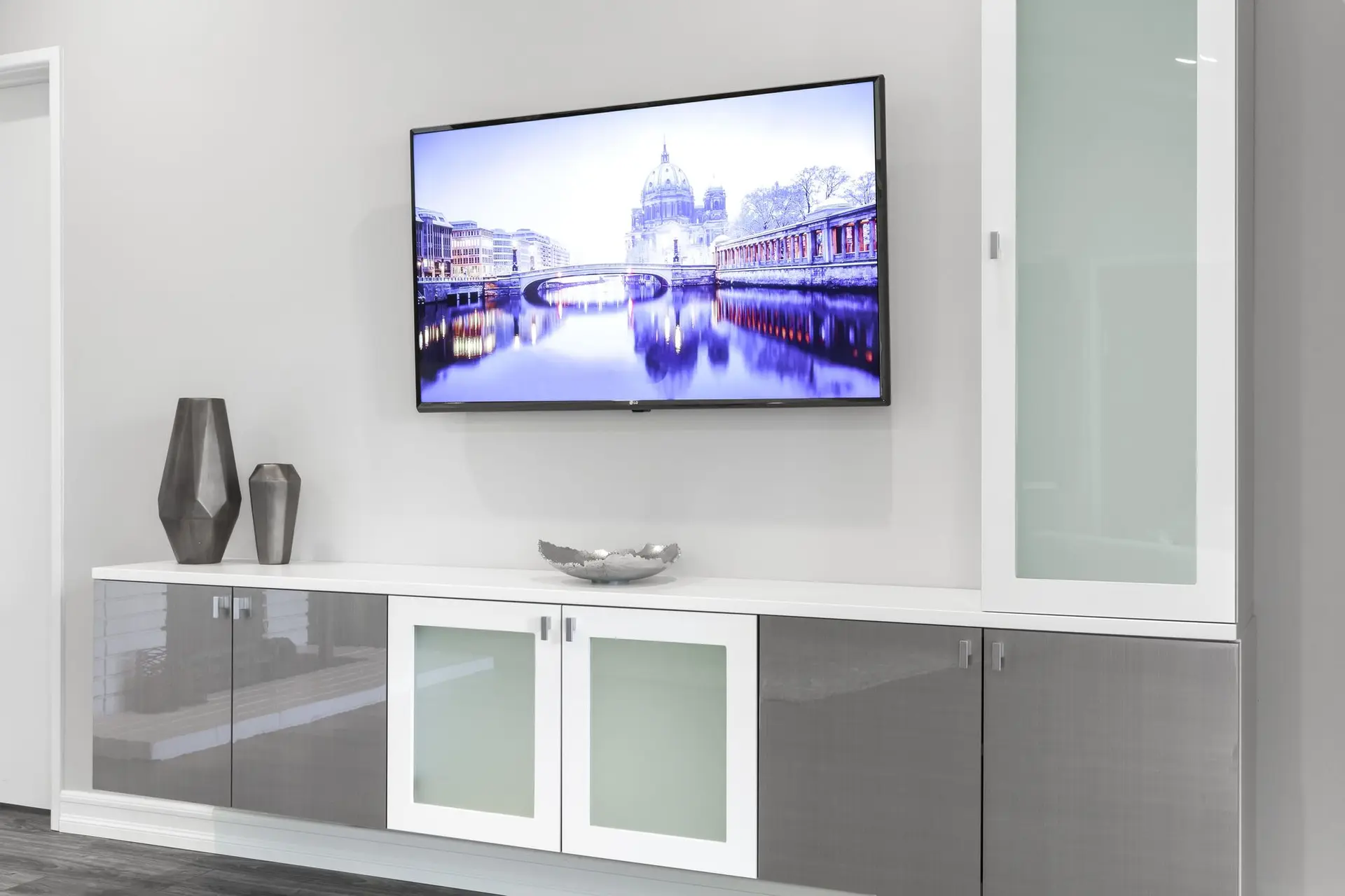 Spacious all white living room wall unit with custom display shelving and lower cabinetry