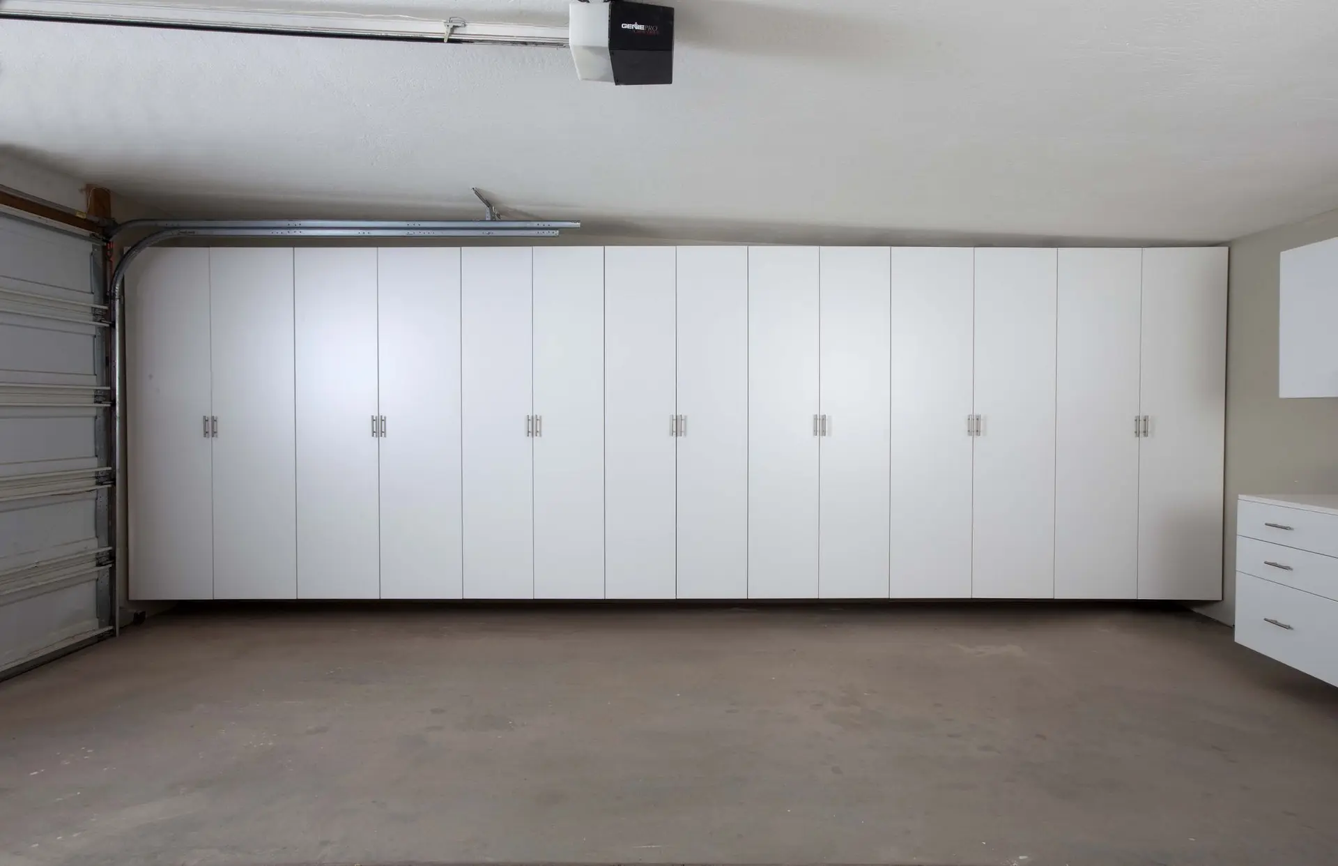 Corner installation of seamless white garage cabinets for streamlined home storage in Boca Raton