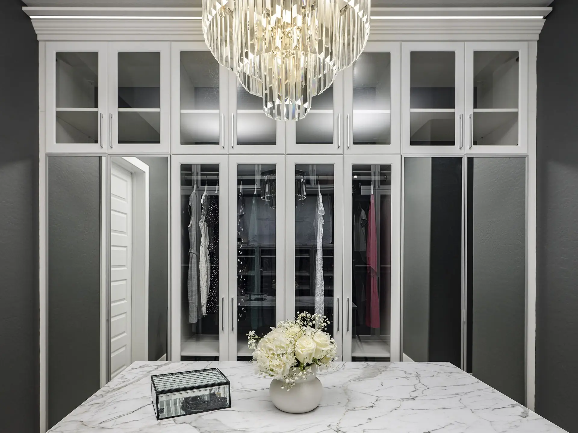 Spacious all-white wardrobe layout with built-in shoe racks and custom cabinetry